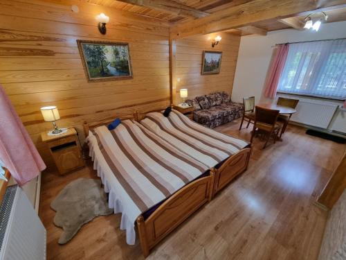 sypialnia z dużym łóżkiem w drewnianym domku w obiekcie Domek Pod Klonem Agroturystyka w Białowieży