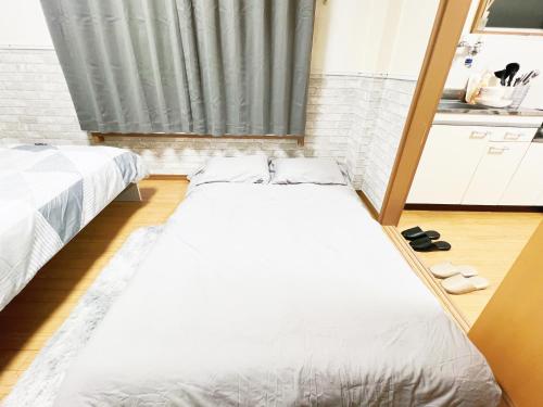 2 łóżka w małym pokoju z kuchnią w obiekcie 西武新宿線 駅近4人可 02 w Tokio