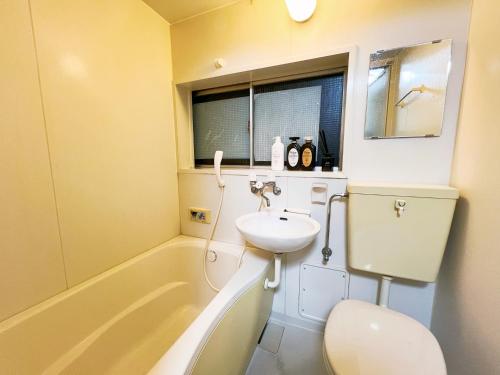 łazienka z umywalką, toaletą i wanną w obiekcie 西武新宿線 駅近4人可 02 w Tokio