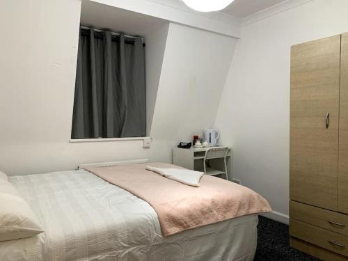 um pequeno quarto com uma cama e uma janela em Warren Street Guest House em Londres