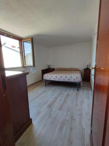 1 dormitorio con 1 cama y suelo de madera en Appartamento Amatrice, en Amatrice