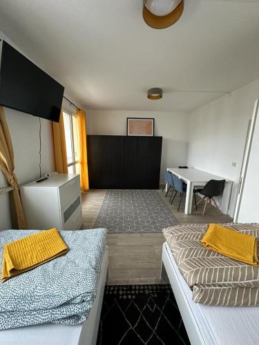 Nietleben的住宿－Ideal für Monteure. 3 Zimmer Apartment mit Küche, Waschmaschine, WiFi usw... .，客房设有两张床、一张桌子和一张桌子。