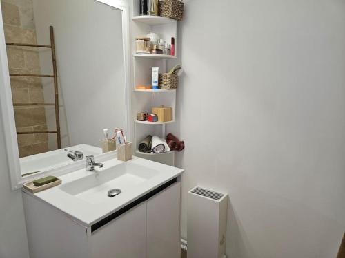 une salle de bain blanche avec un lavabo et un miroir dans l'établissement Hauteur d'Antibes 3 pièces vue mer et montagne Calanques, à Antibes