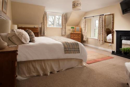 une chambre avec un grand lit et une cheminée dans l'établissement Castle Cottage, Press Mains Farm Cottages, à Eyemouth