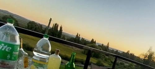 un grupo de botellas sentadas sobre una barandilla con vistas en Terraza vista hermosa, en Lolol