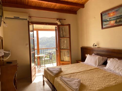 a bedroom with a bed and a balcony at Valmas village in Skiathos Town