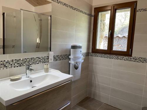 une salle de bain avec un lavabo et une fenêtre dans l'établissement Mas Saucleirette, à Saint-Bresson