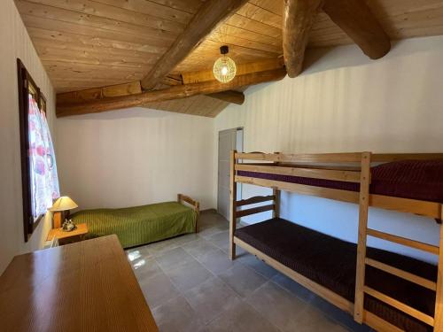 une chambre avec deux lits superposés et une table dans l'établissement Mas Saucleirette, à Saint-Bresson