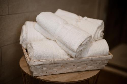 a basket filled with white towels on a table at Palazzo Campia in Cortandone