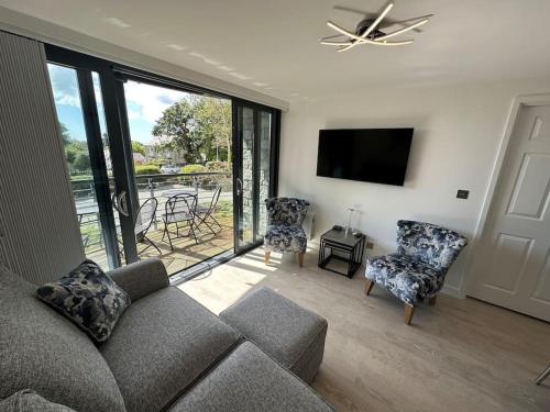 a living room with a couch and chairs and a tv at Polmear Apartments, Charlestown in Charlestown