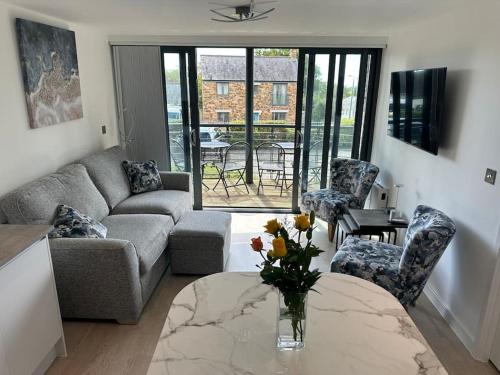 a living room with a couch and a table and chairs at Polmear Apartments, Charlestown in Charlestown