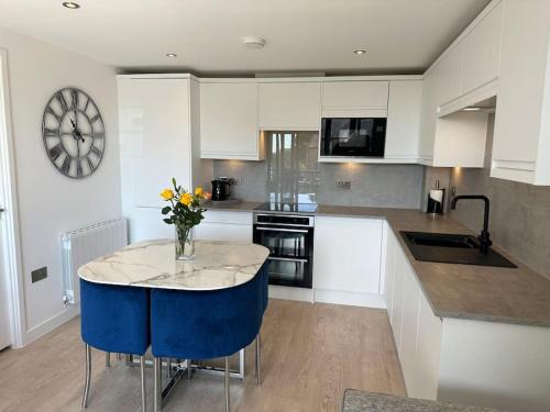 a kitchen with a table with a vase of flowers on it at Polmear Apartments, Charlestown in Charlestown