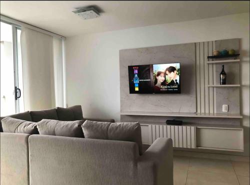 sala de estar con sofá y TV de pantalla plana en Norte Barranquilla amoblado, en Barranquilla