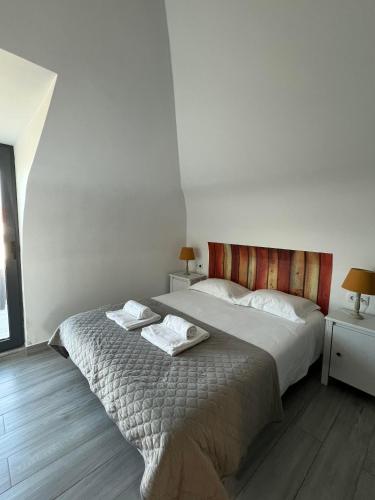 a bedroom with a bed with two towels on it at YEY Baleal in Peniche