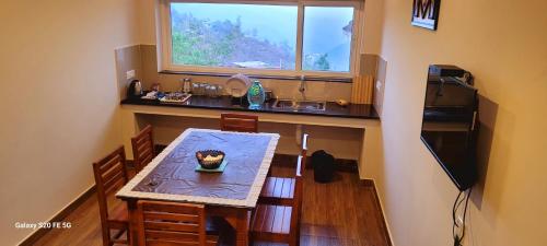 a small kitchen with a table and a window at Sky High Villa Annex in Kodaikānāl