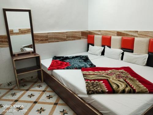 a bedroom with a bed with a mirror on it at Raghav guest house in Mathura
