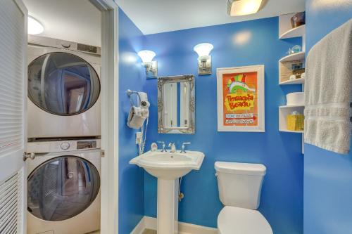 a blue bathroom with a washing machine and a sink at Pensacola Beach Condo with Patio and Access to Beach! in Pensacola Beach