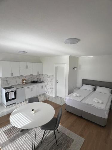 Habitación blanca con cama, mesa y sillas en Saraapartman, en Plav