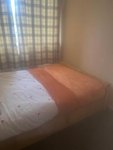 a bed sitting in a room with a window at Basildon Essex Modern 3 Bed House for 7 guests Free Parking and WiFi in Nevendon