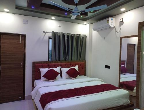 a bedroom with a large bed and a mirror at Hotel Shobhani in Deoghar