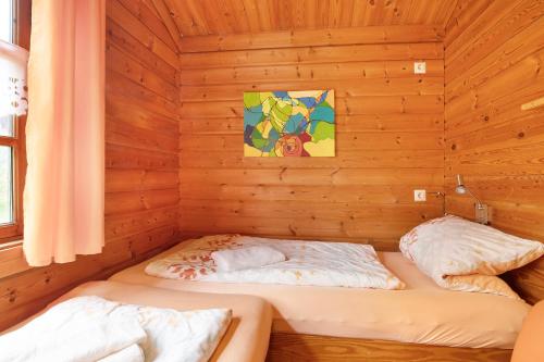 a room with two beds in a wooden cabin at Hüssli Numero 1 in Hayingen