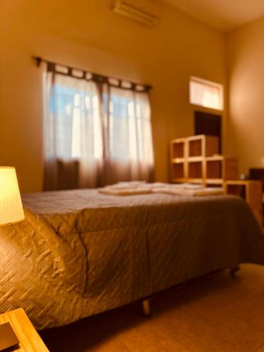 un dormitorio con una cama y una ventana en Quenti apart salta, en Salta