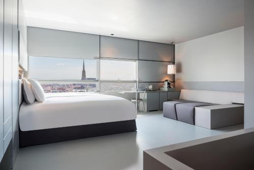 um quarto com uma grande cama branca e uma grande janela em SO/ Vienna em Viena