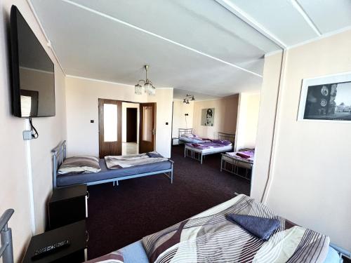 um quarto com duas camas e uma televisão em Hotel Penzion Rohožník em Praga