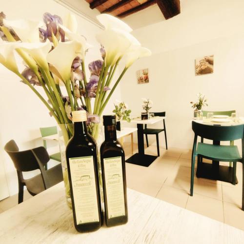 two bottles of wine sitting on a table with flowers at Agriturismo Il Poderuccio in Castiglione dʼOrcia