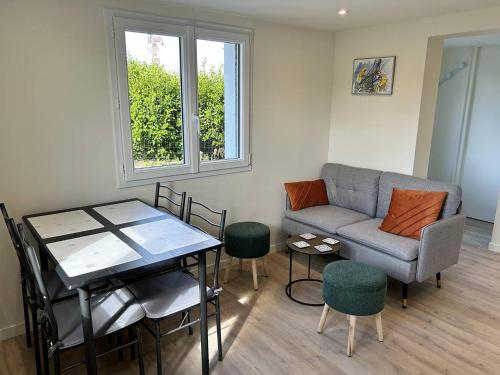 un salon avec un canapé, une table et des chaises dans l'établissement 357 - Appartement T3 à 100m de l'Anse du Croc., à Fréhel