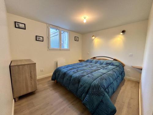 Schlafzimmer mit einem Bett, einem Tisch und einem Fenster in der Unterkunft 357 - Appartement T3 à 100m de l'Anse du Croc. in Frehel