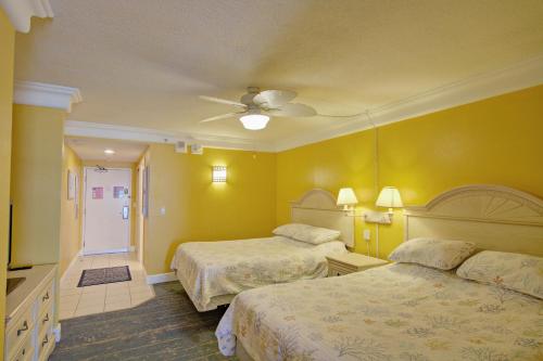 a hotel room with two beds and a ceiling fan at Daytona Beach Resort 260 in Daytona Beach