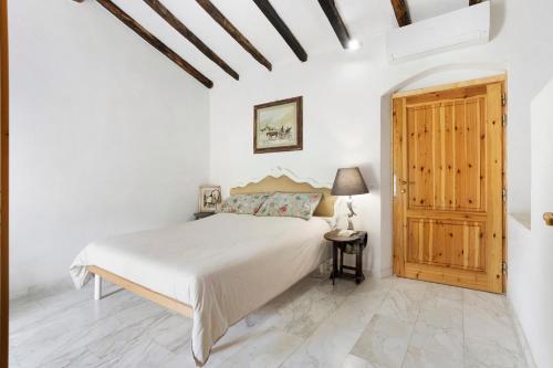 een slaapkamer met een bed en een houten deur bij Villino Marco in Luni