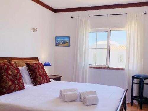 a bedroom with a bed with towels on it at Benagil Beach House - Victoria in Lagoa