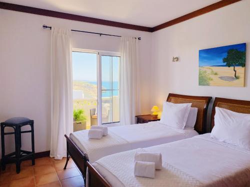 a bedroom with two beds and a large window at Benagil Beach House - Victoria in Lagoa