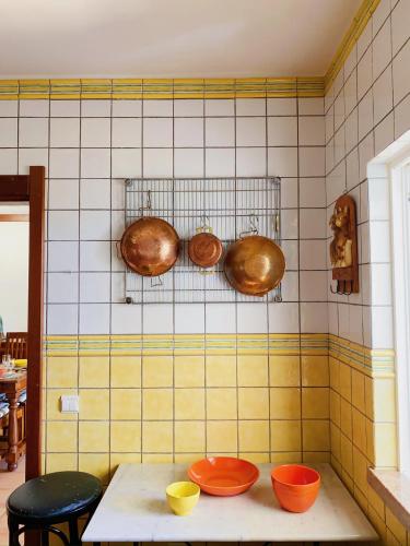 a kitchen with copper pots and pans on the wall at Benagil Beach House - Victoria in Lagoa