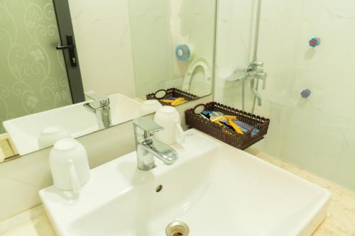a bathroom with a white sink and a mirror at Korea 2 Hotel Bac Giang in Làng Thành