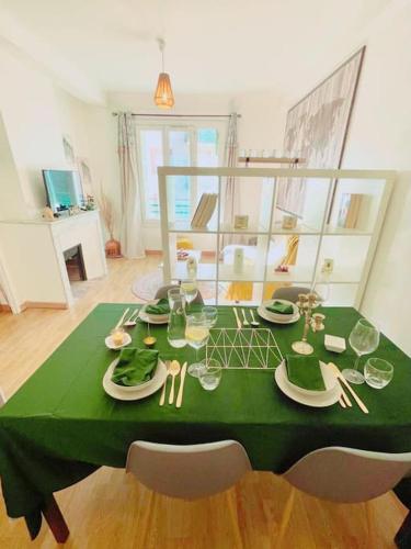 une table verte avec des assiettes et des verres dans l'établissement T2 Aixois centre-clim-netflix, à Aix-en-Provence