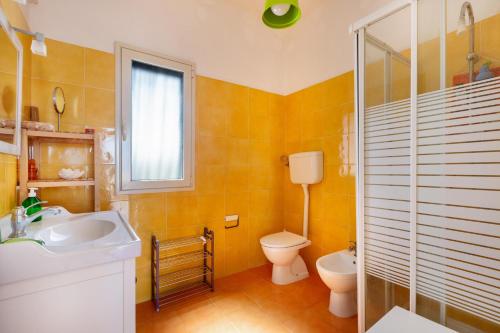 a bathroom with a sink and a toilet and a window at Villa Sierri by Perle di Puglia in Specchiolla 