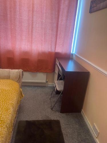 a room with a desk in front of a window at Basildon Essex Modern 3 Bed House for 7 guests Free Parking and WiFi in Nevendon