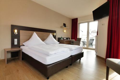 a bedroom with a large bed with a red curtain at Hotel Moseldomizil in Mülheim an der Mosel