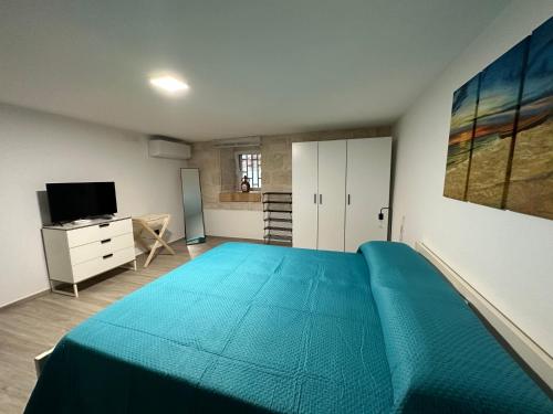 a bedroom with a large blue bed and a television at A Casa di Lella in Giovinazzo
