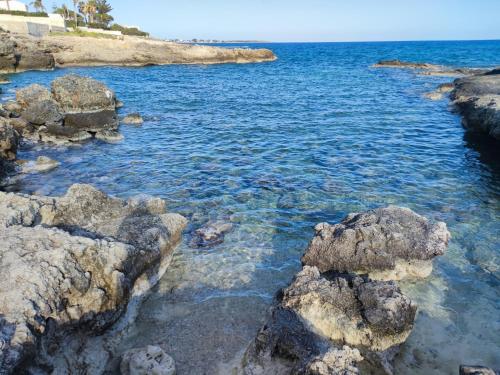 a view of the ocean with rocks in the water at Villa Mykonos in Fontane Bianche
