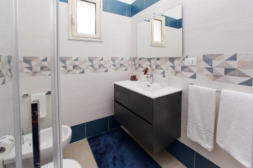 a bathroom with a sink and a toilet and a mirror at Showroom Luxury B&B in Reggio Calabria