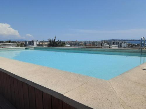 - une grande piscine bleue au-dessus d'un bâtiment dans l'établissement Studio rdj 24 m2 et piscine, à Vallauris