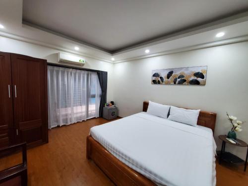 河內的住宿－Dodo Home 3，卧室配有白色的床和窗户。