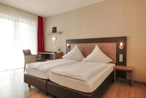 ein Schlafzimmer mit einem großen weißen Bett in einem Zimmer in der Unterkunft Hotel Moseldomizil in Mülheim an der Mosel