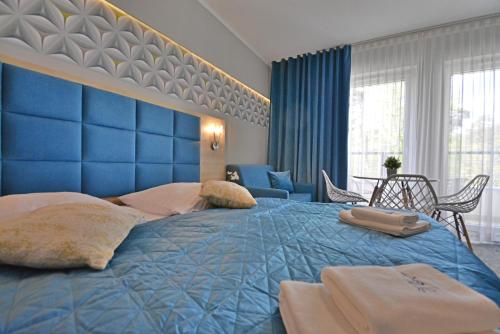 niebieska sypialnia z dużym łóżkiem z niebieskim zagłówkiem w obiekcie Apartamenty Cesarskie - Apartamenty Bryza - Parking w Świnoujściu