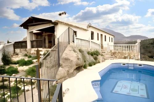 a house with a swimming pool next to a building at 6 bedrooms villa with private pool enclosed garden and wifi at Velez Rubio in Vélez-Rubio