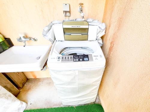 a washing machine in a bathroom next to a sink at コテージマリンロード in Fukai